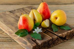 fruta de peras maduras. pera orgánica cosechada en tabla de cortar en mesa de madera. cosecha de otoño. foto
