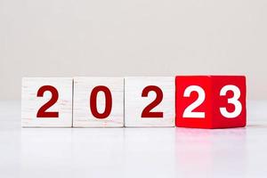 volteando el bloque 2022 a 2023 texto en la mesa. resolución, estrategia, plan, objetivo, motivación, reinicio, negocios y conceptos de vacaciones de año nuevo foto