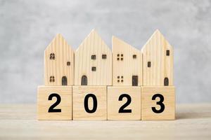 2023 feliz año nuevo con modelo de casa en la mesa. conceptos bancarios, inmobiliarios, de inversión, financieros, de ahorro y de resolución de año nuevo foto