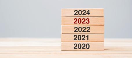 2024 bloque sobre 2023 y 2022 edificio de madera sobre fondo de mesa. planificación empresarial, gestión de riesgos, resolución, estrategia, solución, objetivo, nuevo año nuevo y felices conceptos de vacaciones foto