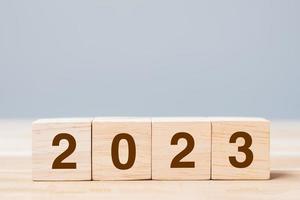 wooden cube block with 2023 text on table background. Resolution, plan, review, goal, start and New Year holiday concepts photo