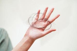 Asian woman have problem with long hair loss attach in her hand. photo
