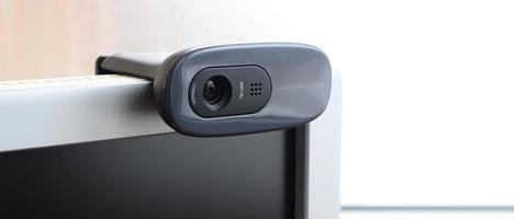 A modern web camera is installed on the body of a flat screen monitor. Device for video communication and recording of high quality video photo