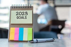 2023 Goal word on note paper with pen on wooden table. Resolution, strategy, solution, goal, business, New Year New You and happy holiday concepts photo