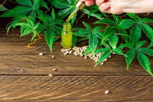 CBD hemp oil, Hand holding bottle of Cannabis oil in pipette photo