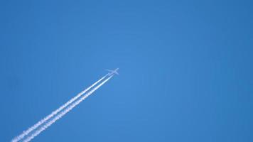 vliegtuig damp wit spoor Aan blauw lucht, vliegtuig laag verontreiniging video