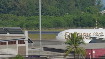 phuket, thaïlande 1er décembre 2018 - passager boeing 777 d'emirates airlines taxis vers le terminal après l'atterrissage à l'aéroport international de phuket. concept international de tourisme et de voyage video