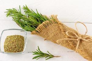 Rosemary bound in burlap cloth on a wooden white board photo