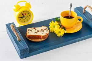 Slices of pound cake with raisins and a cup of coffee served on a tray. Morning tasty breakfast photo