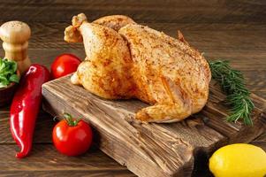 Roasted chicken with spices on wooden background. Healthy food, diet or cooking concept photo