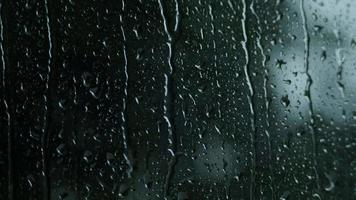 Rain drops on the glass. Small raindrop rests on glass while raining. video