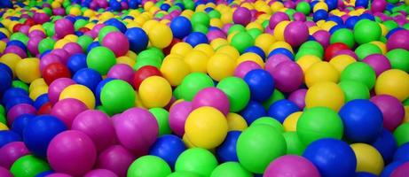 Many colorful plastic balls in a kids' ballpit at a playground. Close up pattern photo