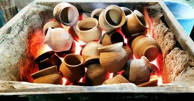Heating clay pots in coal to make tea photo