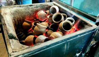 Heating clay pots in coal to make tea photo