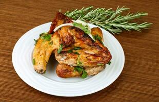 Chicken wings on the plate and wooden background photo