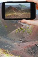 tourist taking photo of path on slope of craters