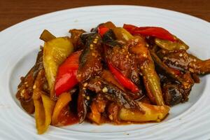 Roasted vegetables on the plate and wooden background photo