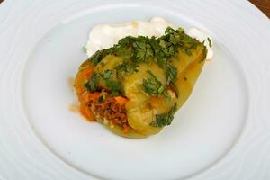 pimiento relleno en el plato y fondo de madera foto