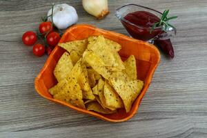 nachos en un bol sobre fondo de madera foto