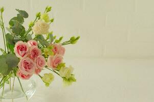 jarrón con hermosas rosas, eustoma y flores de eucalipto en la mesa, espacio para texto. tierna tarjeta de felicitación para vacaciones
