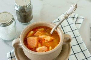 homemade soup with salmon with bread sticks on marble background. photo