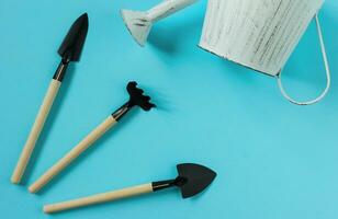Gardening tools on blue background. Spring garden works concept. Top view. Copy space. photo