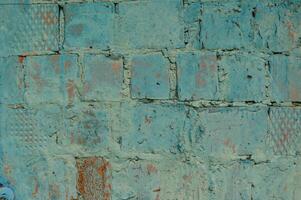 Weathered blue stained old brick wall background photo