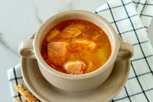 homemade soup with salmon with bread sticks on marble background. photo