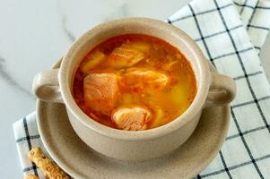 homemade soup with salmon with bread sticks on marble background. photo