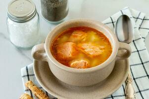 homemade soup with salmon with bread sticks on marble background. photo