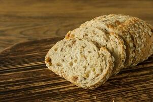 Gluten-free vegan bread and no animal products. Vegetarian bread with oatmeal, banana flavor, on a wooden rustic table, sliced and ready to serve. photo