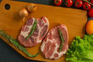 Sliced pieces of raw Meat for barbecue on wooden board, menu cooking recipes. Food, raw steak, beef steak bbq, tomatoes, peppers, spices for cooking meat. photo