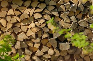 Stacked firewood close-up. Firewood storage, Stocks of wooden logs. Logging in the village. Rustic lifestyle. Wooden texture. photo