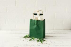 Bottles with Cannabis herbal vegan gluten and lactose free milk and cannabis leaves on wooden table photo