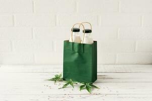 Bottles with Cannabis herbal vegan gluten and lactose free milk and cannabis leaves on wooden table photo