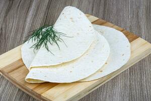 tortillas en tablero de madera y fondo de madera foto