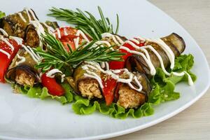 Eggplant roll on the plate and wooden background photo