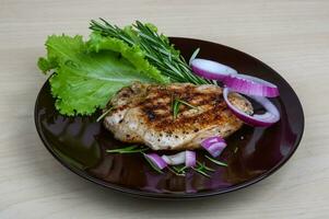 Pork steak on the plate and wooden background photo