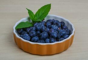 Blueberry in a bowl on wooden background photo