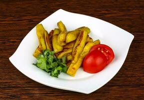 Frid eggplant on the plate and wooden background photo