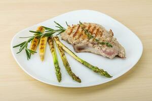 Pork steak on the plate and wooden background photo