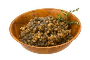 Backed lentils in a bowl on white background photo