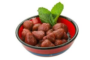 Marinated strawberry in a bowl on white background photo