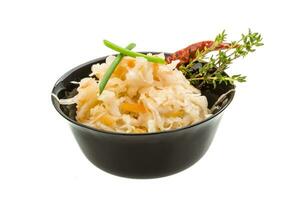 Fermented cabbage in a bowl on white background photo