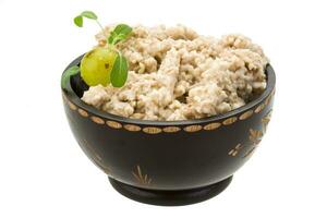 Oats porridge in a bowl on white background photo