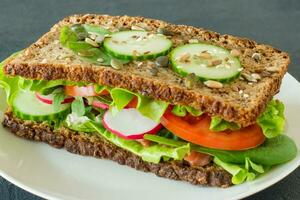 Homemade healthy wholegrain sandwiches with vegetables and smoked salmon. Tasty breakfast and healthy eating concept photo