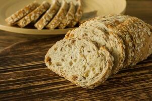 Gluten-free vegan bread and no animal products. Vegetarian bread with oatmeal, banana flavor, on a wooden rustic table, sliced and ready to serve. photo