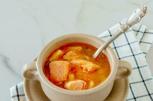 homemade soup with salmon with bread sticks on marble background. photo