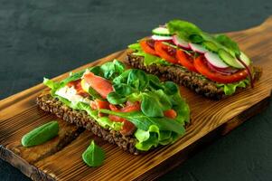 vegetables and smoked open sandwiches with cottage cheese, lattice, tomatoes and lemon on a wooden desk. Healthy breakfast for diet photo
