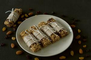 homemade granola energy bars with almond and raisins on black background. Healthy food photo